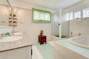 a bathroom with a tub and a sink and a shower at Flo Villa in La Gaulette