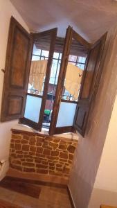 un conjunto de tres ventanas en una pared de ladrillo en Un Tuffo nel passato "B&B Santu Giuvanni" en Fonni