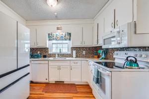 cocina blanca con electrodomésticos blancos y ventana en Greenville Home 2 Mi to Downtown!, en Greenville