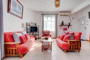 ein Wohnzimmer mit zwei roten Sofas und einem TV in der Unterkunft Flo Villa in La Gaulette