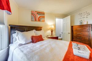 ein Schlafzimmer mit einem weißen Bett mit einem roten Kissen in der Unterkunft Greenville Home 2 Mi to Downtown! in Greenville