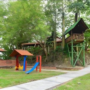 un parque infantil con una casa en el árbol y un tobogán en Hotel Tekal del Rio en Puerto Boyacá