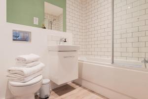 a bathroom with a toilet and a sink and a tub at Modern 1 Bed Apartment, Nightingale Quarter Derby in Derby