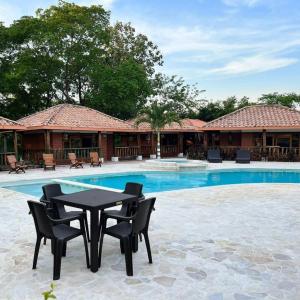 un patio con mesa y sillas junto a una piscina en Hotel Tekal del Rio en Puerto Boyacá