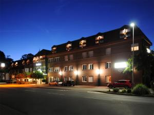 a building with cars parked in front of it at night at Hotel-Restaurant Thomsen in Delmenhorst