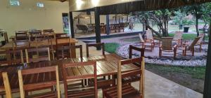 Mfuwe的住宿－KUDU SAFARI LODGE (Mfuwe, Zambia)，用餐室配有木桌和椅子