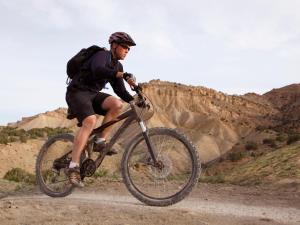 um homem a andar de bicicleta numa estrada de terra batida em New Rabbitbrush Hideaway Studio Trails Steps Away em Grand Junction