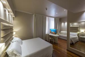 a hotel room with a bed and a television at Hotel Touring in Ferrara