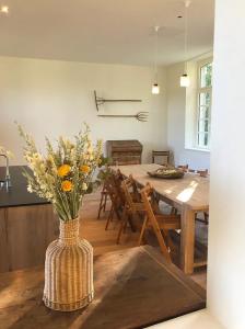 a vase with flowers sitting on a table in a kitchen at Domaine du Château de Haltinne-Maison du Jardinier in Gesves