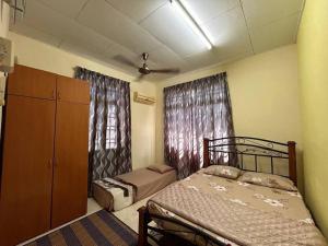 um quarto com 2 camas, um armário e cortinas em Homestay Jitra Zultie's em Jitra