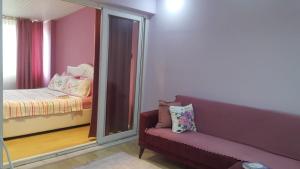 a room with a couch and a window with a bed at Samlife Apart in Samsun