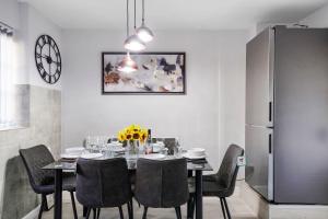 Spacious, 4 bed, Garden, Parking, ExCel London في لندن: غرفة طعام مع طاولة وكراسي وثلاجة