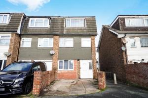 a car parked in front of a brick house at Spacious, 4 bed, Garden, Parking, ExCel London in London