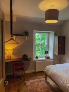 a bedroom with a bed and a desk and a window at Unique Highland in Inverness