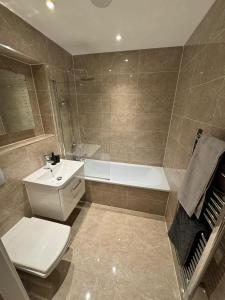a bathroom with a toilet and a sink and a tub at Seven Space 2 Bed 2 Bath Central Apartment in Norwich
