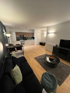 a living room with a black couch and a table at Seven Space 2 Bed 2 Bath Central Apartment in Norwich