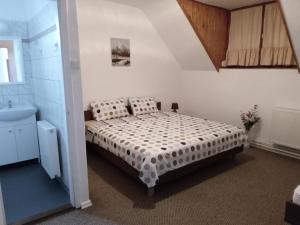 1 dormitorio con cama y lavamanos en SZIESZTA APARTMAN, en Gárdony