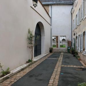 une allée vide dans un bâtiment blanc avec une porte dans l'établissement Appartement Salamandre, à Orléans