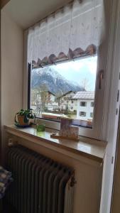 a window with a radiator and a view of a mountain at Appartement Auszeit in Holzgau
