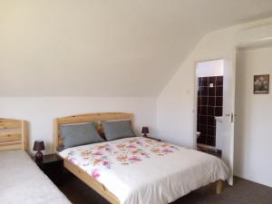 ein Schlafzimmer mit einem großen weißen Bett mit einer Blumenbettdecke in der Unterkunft SZIESZTA APARTMAN in Gárdony
