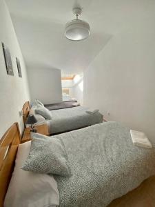 um quarto com 3 camas e uma luz em Apartamento Espert Biescas em Biescas