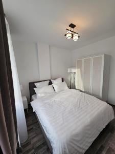 a bedroom with a large bed with white sheets and pillows at Maria's Premium Suite in Baia Mare