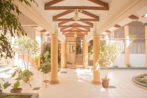 a lobby with columns and plants in a building at Hostal España in Sucre