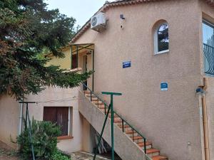 una casa con una escalera que conduce a una puerta en Appartement classé 3 étoiles au 1er étage d'une maison avec jardin dans un quartier calme en Cavalaire-sur-Mer