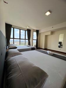 - une grande chambre avec 2 lits et une grande fenêtre dans l'établissement One Soho, à Subang Jaya