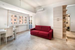 - un salon avec une chaise rouge et un bureau dans l'établissement Appartamento Romantico a Trastevere, à Rome