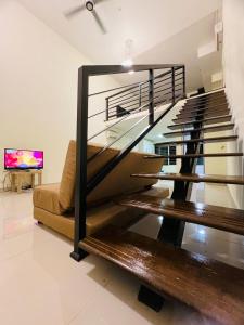 un escalier avec une balustrade en verre dans le salon dans l'établissement One Soho, à Subang Jaya
