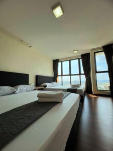 - 2 lits dans une chambre avec de grandes fenêtres dans l'établissement One Soho, à Subang Jaya