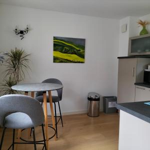 - une cuisine avec deux tabourets de bar et une table dans l'établissement Appartement Salamandre, à Orléans