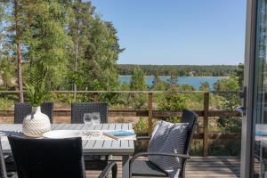 a table and chairs on a deck with a view of a lake at Bergs Gård & Hållsvikens Gård in Västerljung