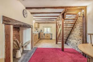 een woonkamer met een trap en een bakstenen muur bij Bluebell Cottage in Ross on Wye