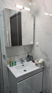 a white bathroom with a sink and a mirror at Alfa-Central Luxury Condo by Optimum Link in Katerini +16 photos