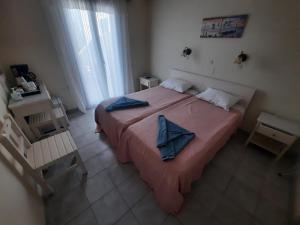 a bedroom with a bed with two blue towels on it at Jasmine in Parikia