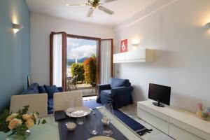 Una sala de estar con una mesa y un televisor. en Lakefront Belvedere by Garda FeWo, en Manerba del Garda