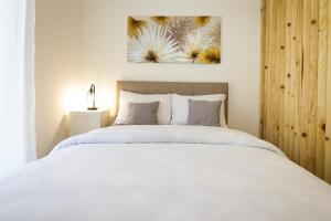 Vrnjačka BanjaにあるApartman IRISの白いベッドと壁に絵画が飾られたベッドルーム1室