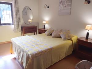 ein Schlafzimmer mit einem Bett mit zwei Nachttischen und einem Spiegel in der Unterkunft Apartamento Sintra in Sintra