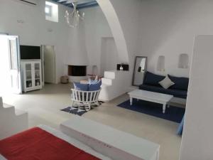 a living room with a blue couch and a table at Jasmine Suites Poolhouse Rhodos in Koskinou