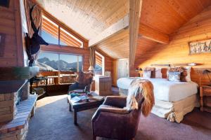 a bedroom with a bed and a fireplace in a cabin at Hôtel Au Chamois d'Or by Les Etincelles in L'Alpe-d'Huez