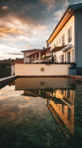 un reflejo de un edificio en un charco de agua en Peterc Vineyard Estate, en Kojsko