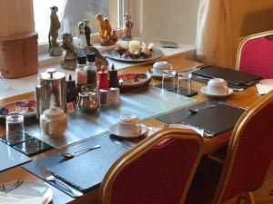 una mesa con platos de comida encima en glenardran house en Crianlarich