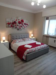 een slaapkamer met een groot bed en een rode deken bij Casa Romolo in Garda