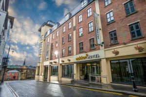 a large brick building on a city street at Maldron Hotel Derry in Derry Londonderry