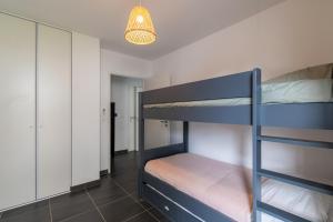 1 Schlafzimmer mit 2 Etagenbetten und einer Lampe in der Unterkunft Appartement 70 m2 climatisé avec balcon et parking in Marseille