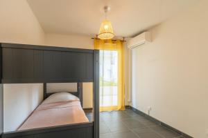 ein Schlafzimmer mit einem schwarzen Etagenbett und einem Fenster in der Unterkunft Appartement 70 m2 climatisé avec balcon et parking in Marseille