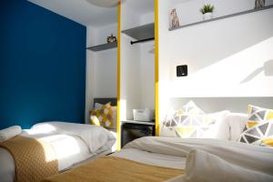 1 dormitorio con 2 camas y pared azul en London City Self Check-in Luxury Rooms en Londres