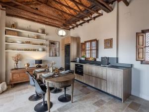 ein Esszimmer mit einem Tisch und einer Küche in der Unterkunft Carmen de Azahar in Granada
